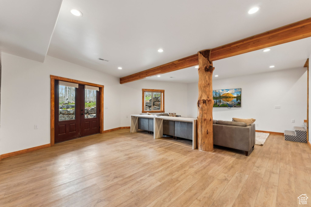 Living room featuring recessed lighting, baseboards, light wood-style floors, beamed ceiling, and french doors