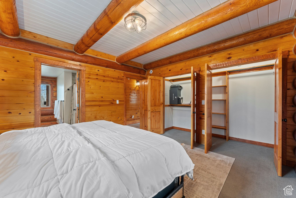 Bedroom with carpet, wood ceiling with exposed beams, and baseboards