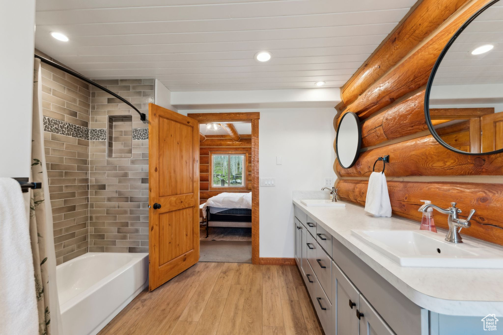 Full bathroom with wood finished floors, double vanity, recessed lighting, shower / bath combination, and connected bathroom