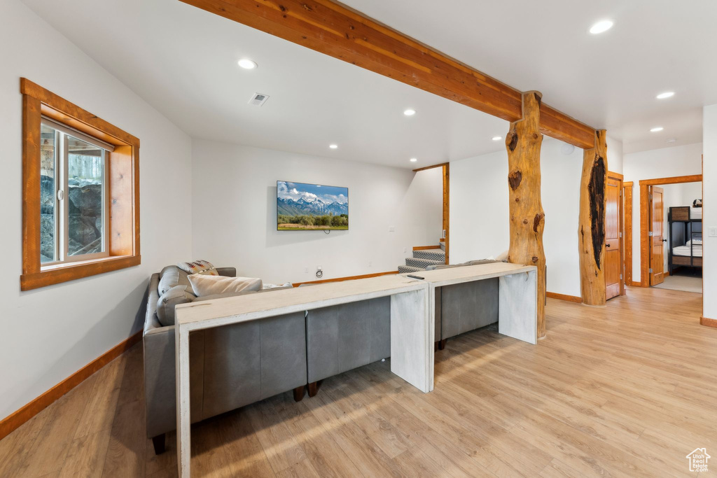 Living room featuring recessed lighting, light wood-style floors, baseboards, and stairway