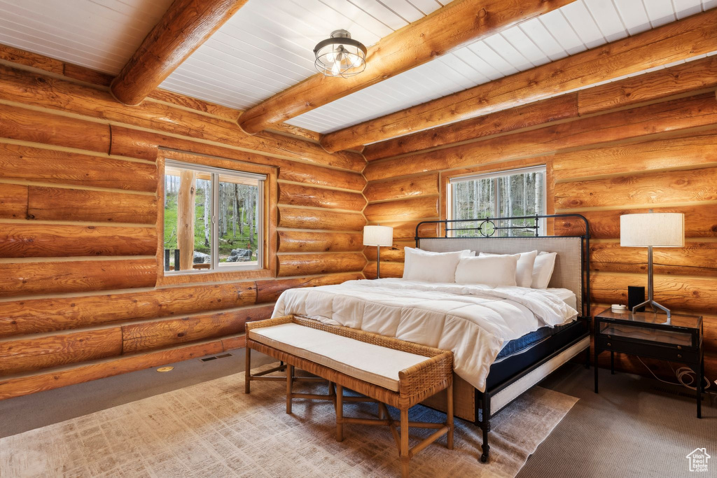 Bedroom with multiple windows and beamed ceiling