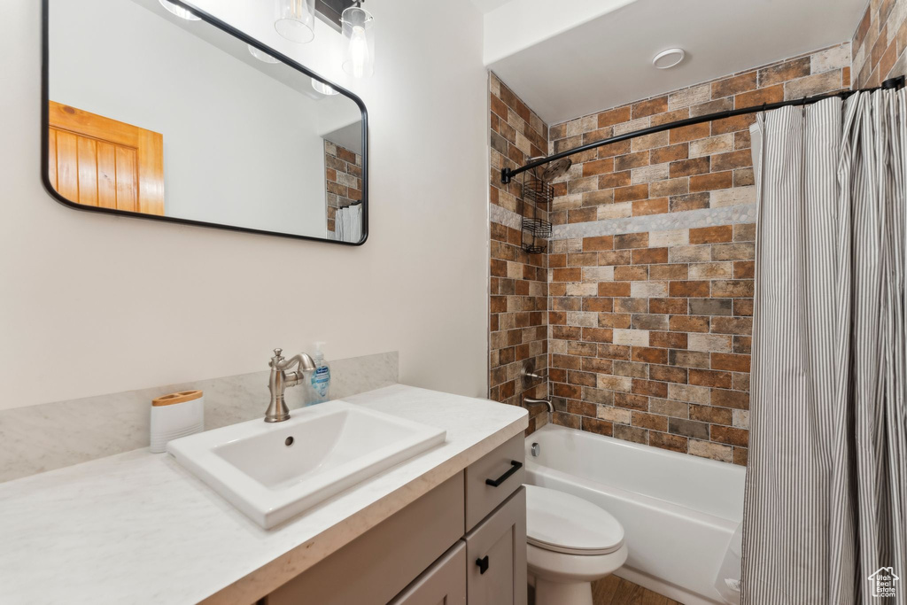 Full bathroom with vanity, shower / tub combo, and toilet