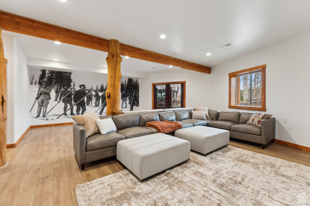 Living area featuring recessed lighting, light wood-style floors, healthy amount of natural light, beam ceiling, and baseboards