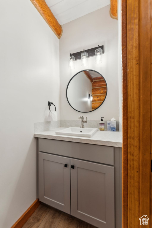 Bathroom featuring vanity, wood finished floors, and baseboards