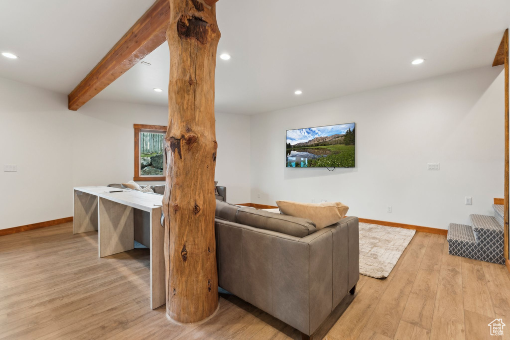 Living room with light wood-type flooring, baseboards, beamed ceiling, and recessed lighting