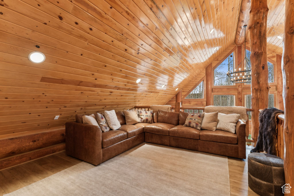 Living room with wood ceiling, lofted ceiling, light wood-style floors, and wooden walls