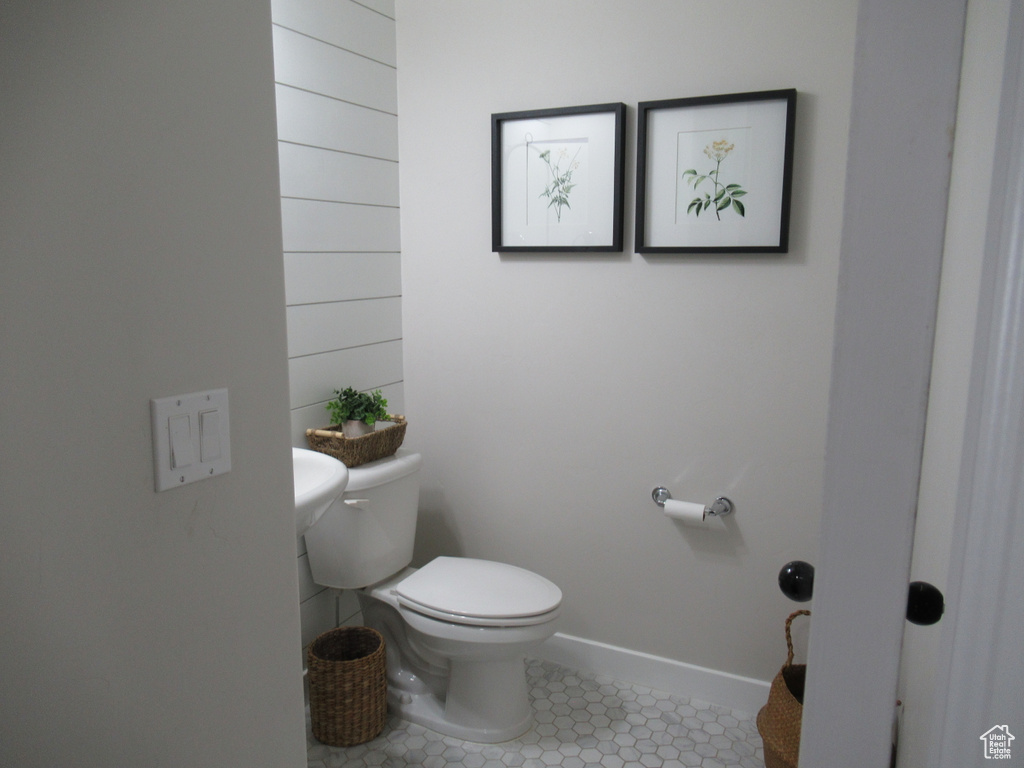 Bathroom featuring toilet, tile patterned floors, and baseboards