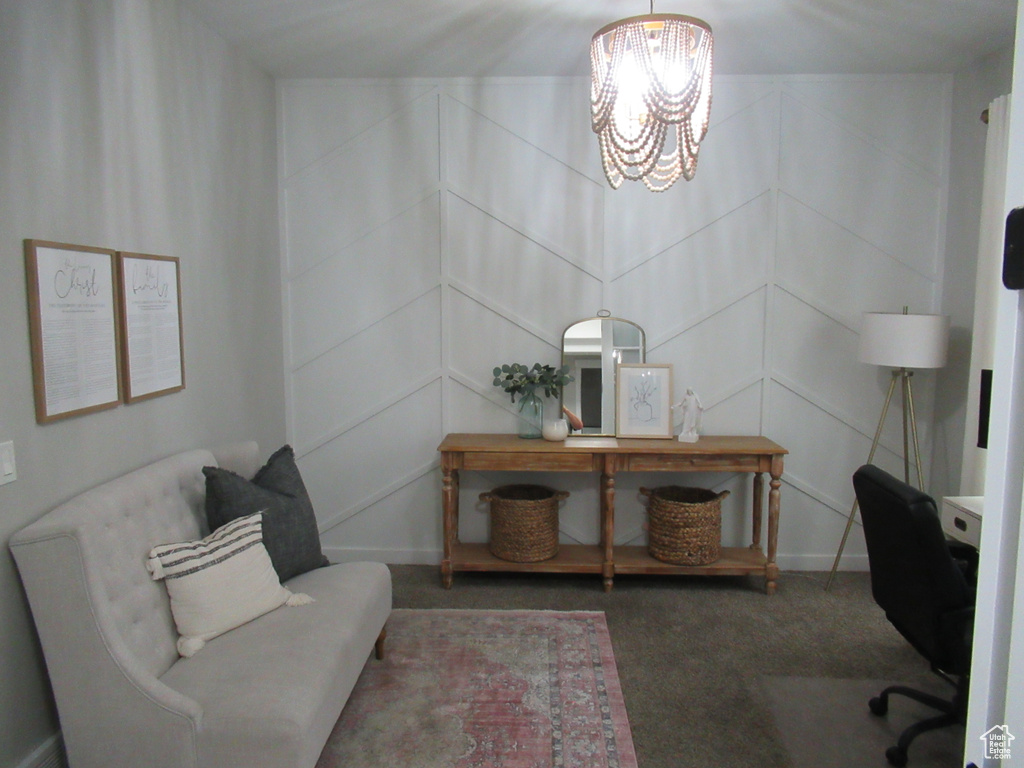 Carpeted office featuring a chandelier and a decorative wall