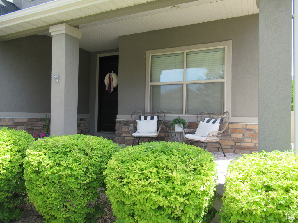 Doorway to property featuring stone siding and stucco siding