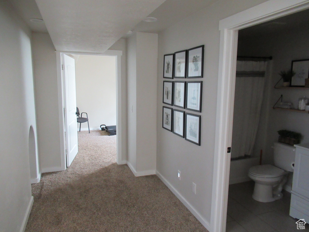 Hallway with carpet flooring and baseboards