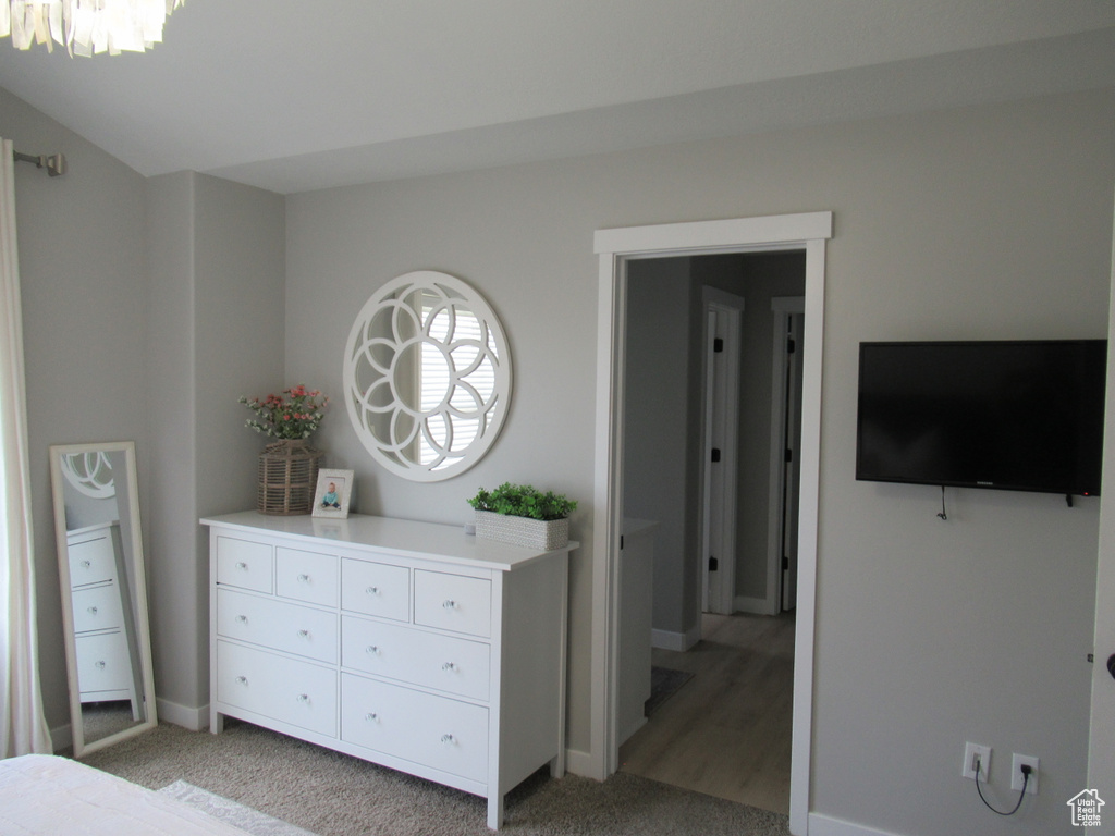 Bedroom with baseboards, light colored carpet, and a chandelier