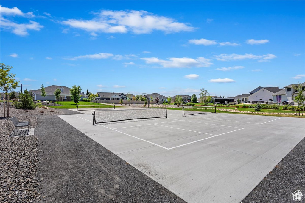 View of tennis court with a residential view