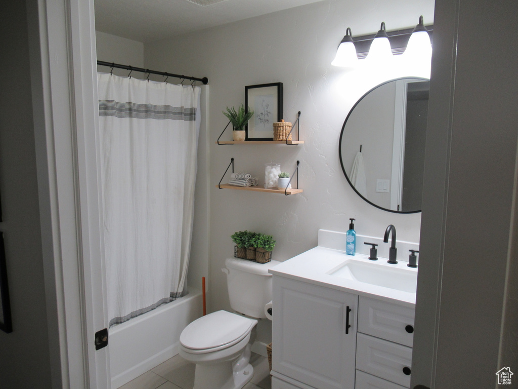 Bathroom with vanity, toilet, tile patterned flooring, and shower / bath combo