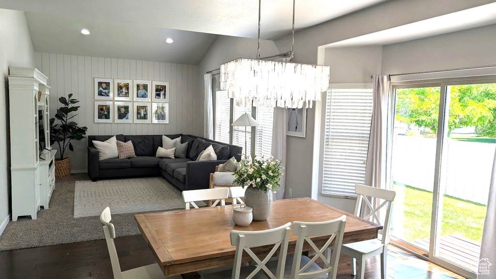 Dining area featuring wood finished floors, lofted ceiling, a chandelier, recessed lighting, and baseboards