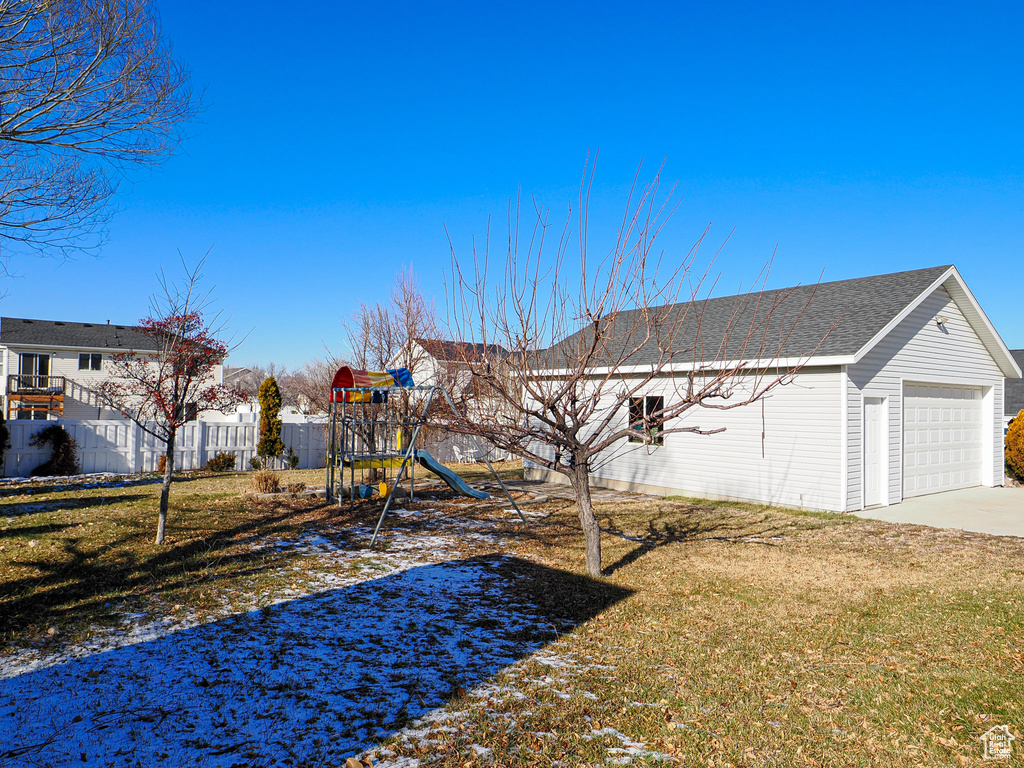 View of yard featuring a playground and a garage
