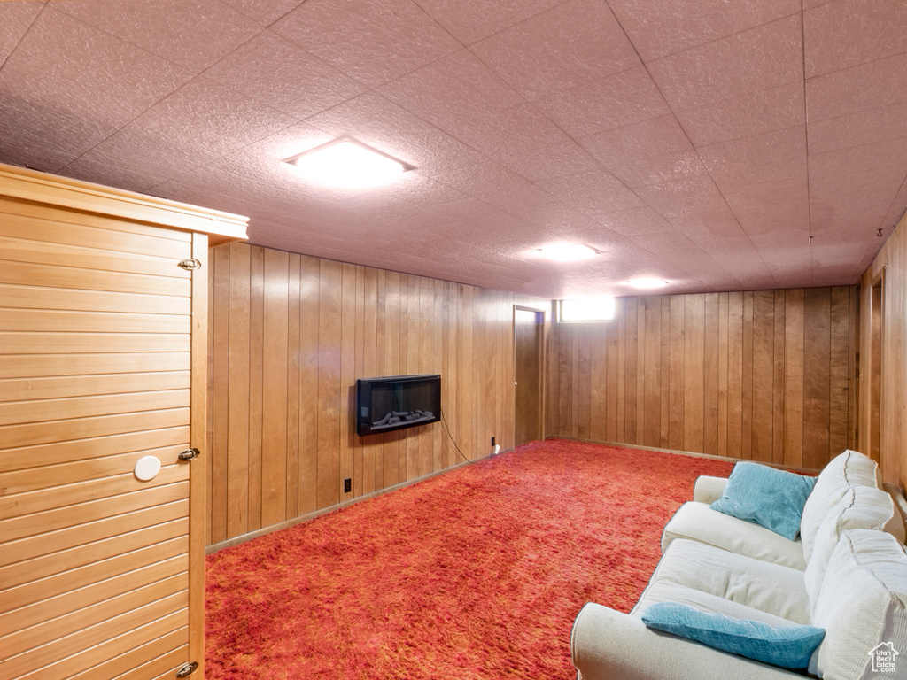 Living area with wooden walls and carpet flooring