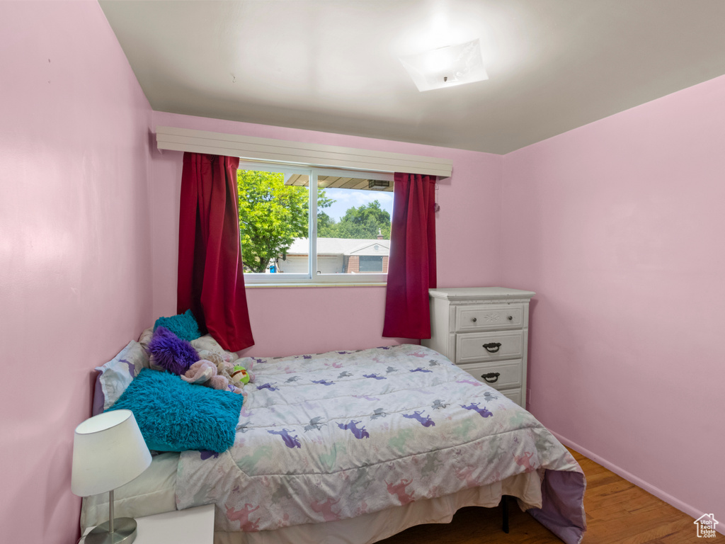 Bedroom featuring wood finished floors and baseboards