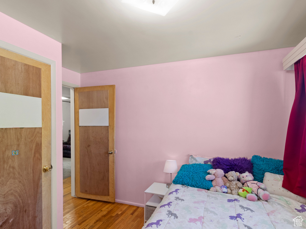 Bedroom with wood finished floors and baseboards