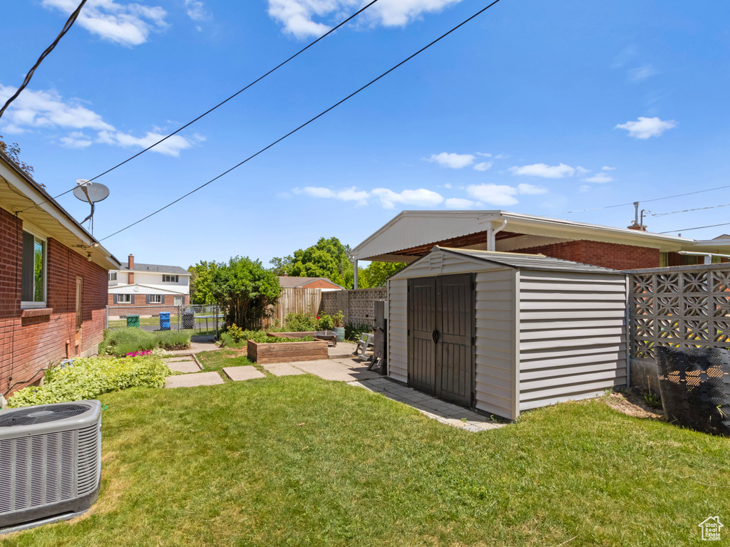 View of yard with central AC and a garden