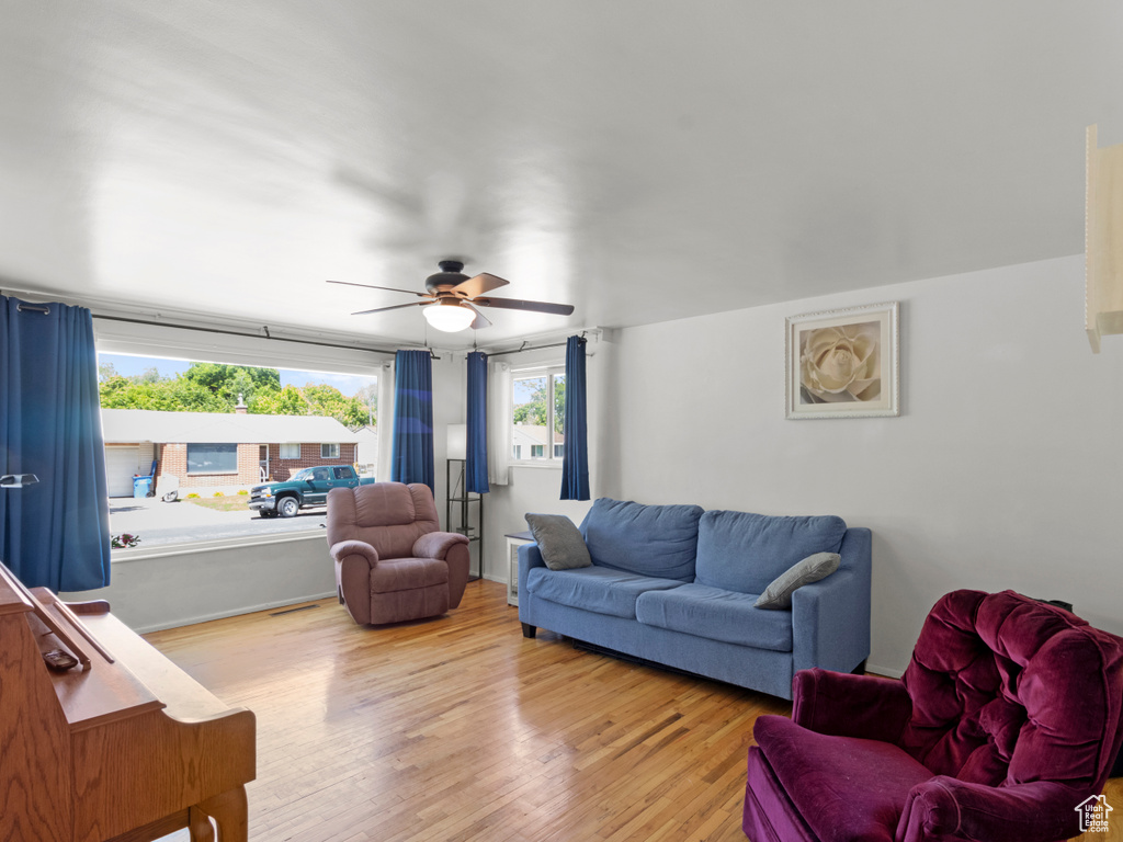 Living room with light wood-type flooring and a ceiling fan