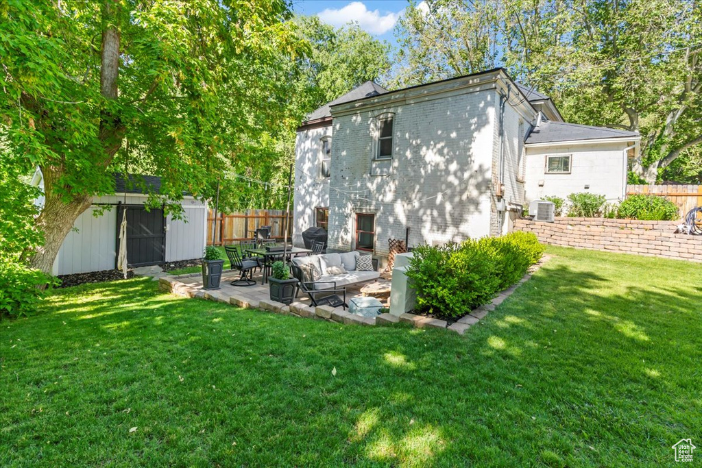 Rear view of property with brick siding, a patio, and central AC unit