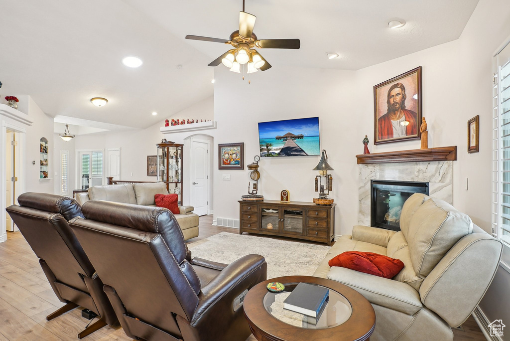 Living area featuring a high end fireplace, ceiling fan, vaulted ceiling, plenty of natural light, and recessed lighting