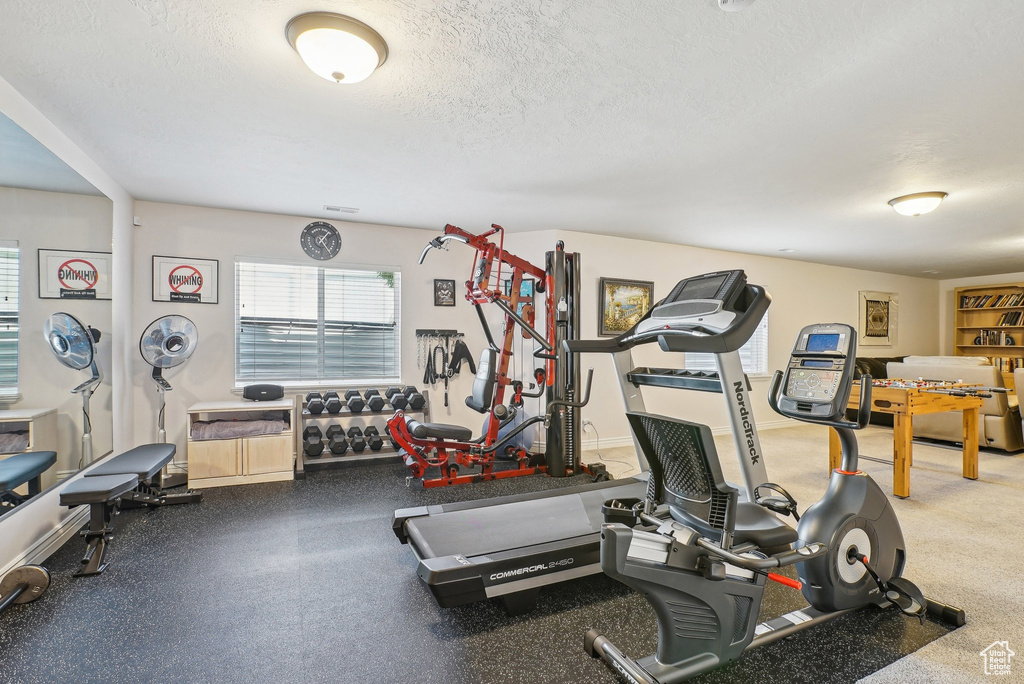 Exercise room featuring plenty of natural light and a textured ceiling