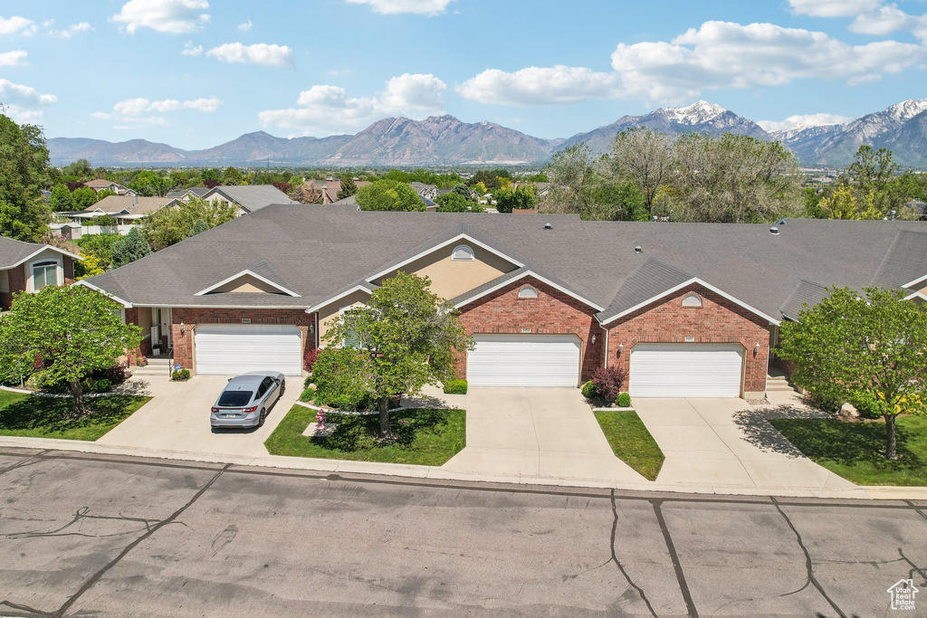 View of front facade featuring brick siding, concrete driveway, and a mountain view