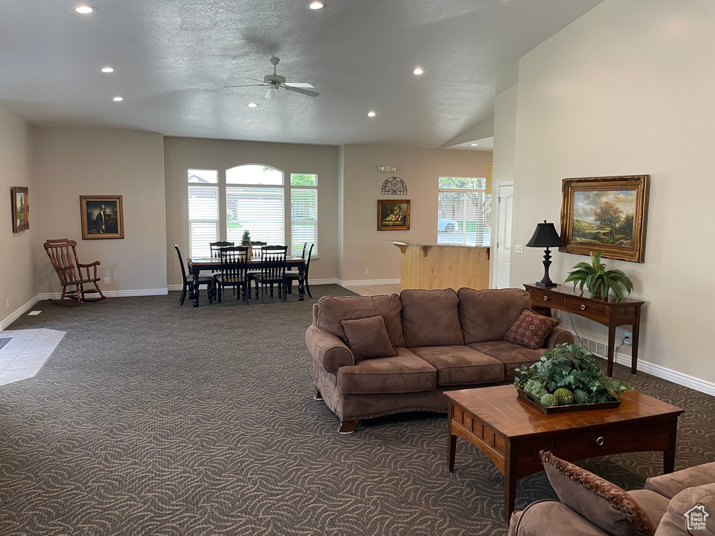 Carpeted living area with ceiling fan, recessed lighting, plenty of natural light, and baseboards