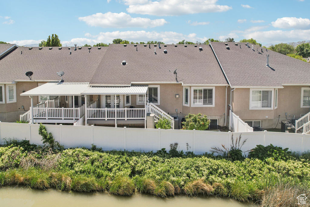 Back of house with a fenced backyard, stucco siding, and a shingled roof