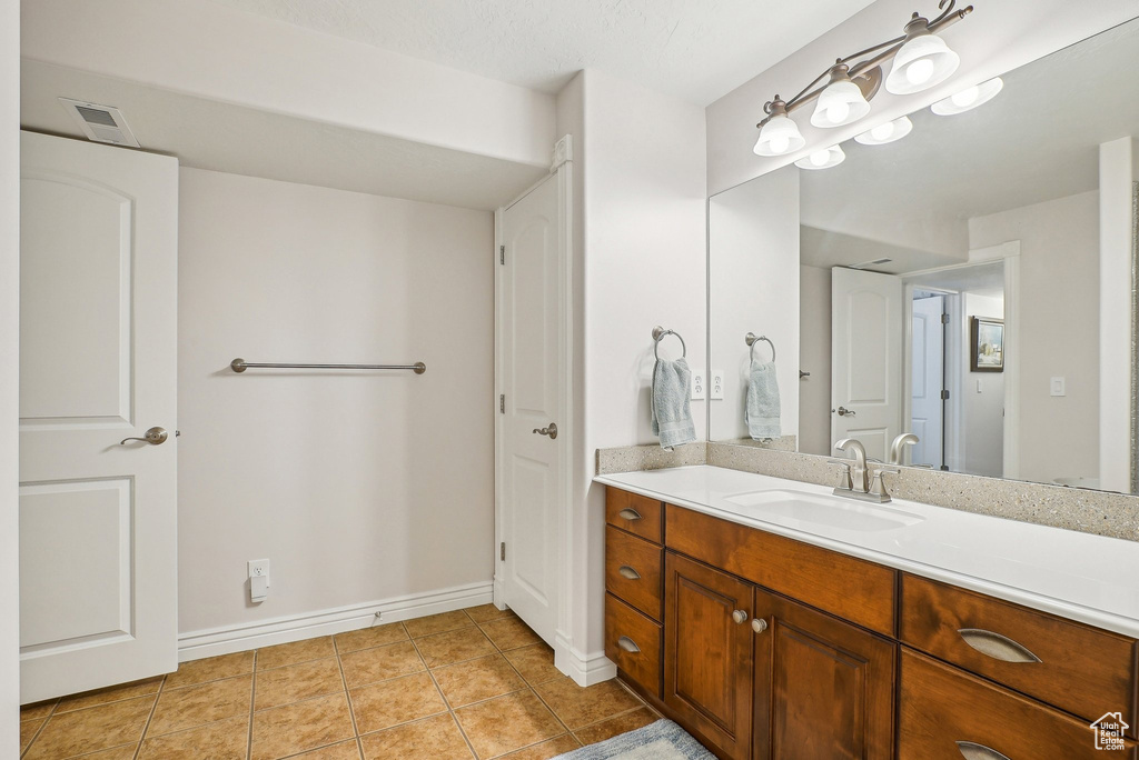 Bathroom with vanity, tile patterned floors, and baseboards