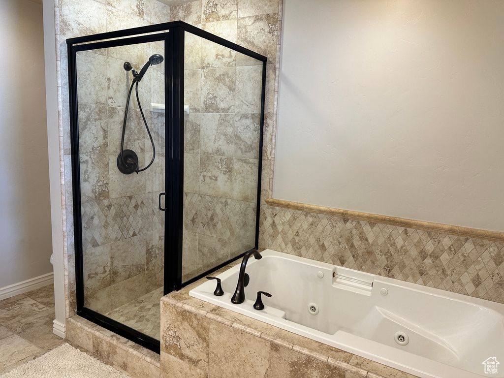 Bathroom featuring a tub with jets and a stall shower
