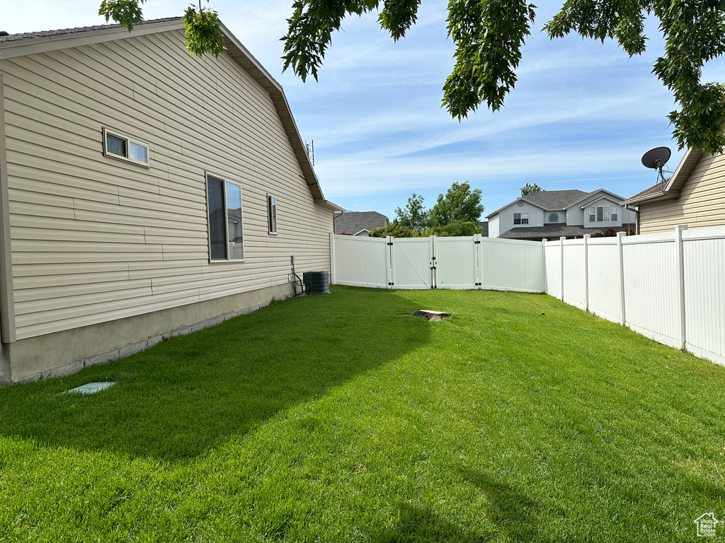 View of yard featuring a gate and central AC unit