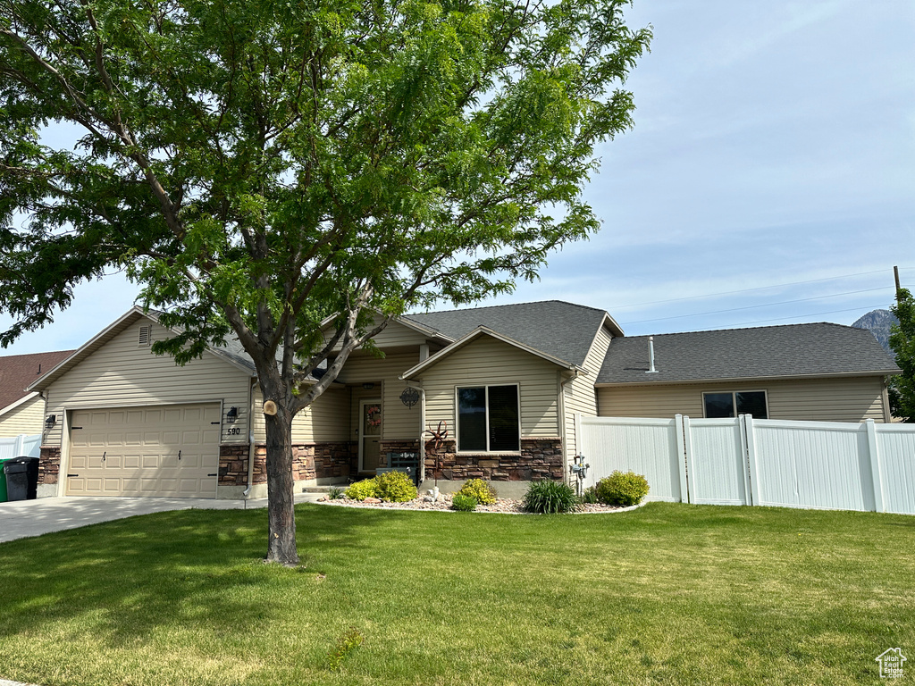 View of front of home with a garage, stone siding, concrete driveway, and a shingled roof