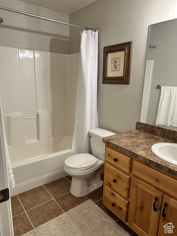 Full bathroom with vanity, shower / bath combination with curtain, toilet, and tile patterned flooring