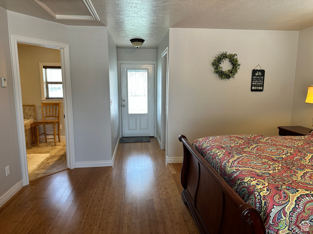 Bedroom featuring wood finished floors, baseboards, and a textured ceiling