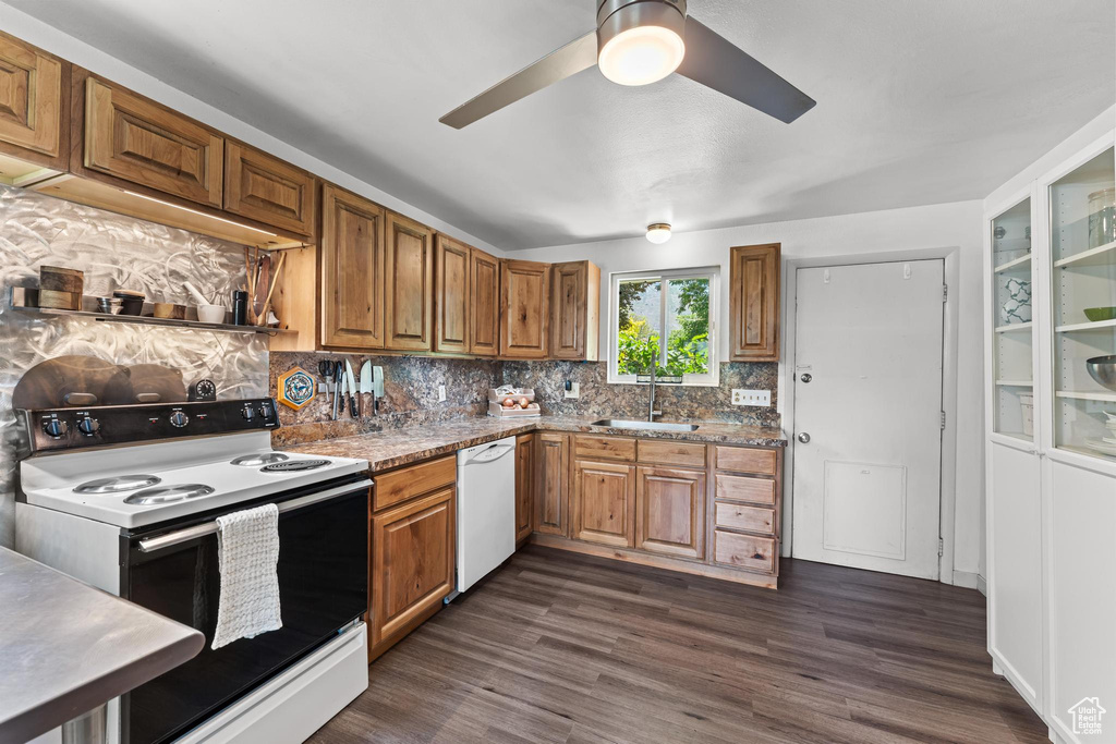 Kitchen with electric range, dishwasher, tasteful backsplash, ceiling fan, and a sink