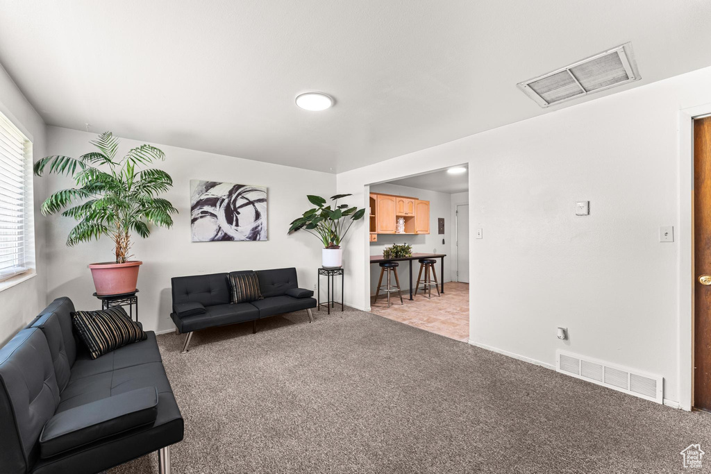 Living area featuring light carpet and baseboards