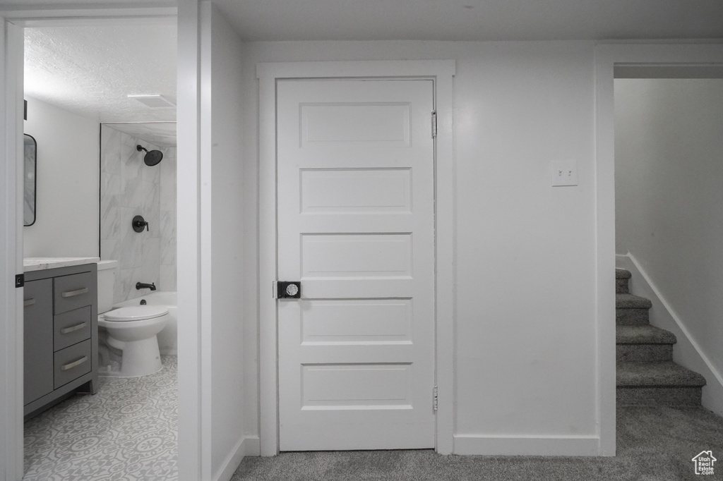 Full bath with vanity, toilet, baseboards, shower / washtub combination, and a textured ceiling