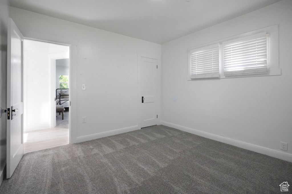 Spare room featuring carpet flooring and baseboards