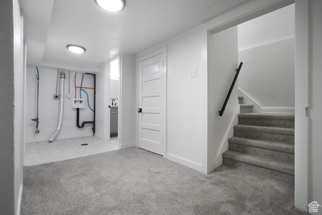Finished below grade area featuring carpet flooring, stairs, and baseboards