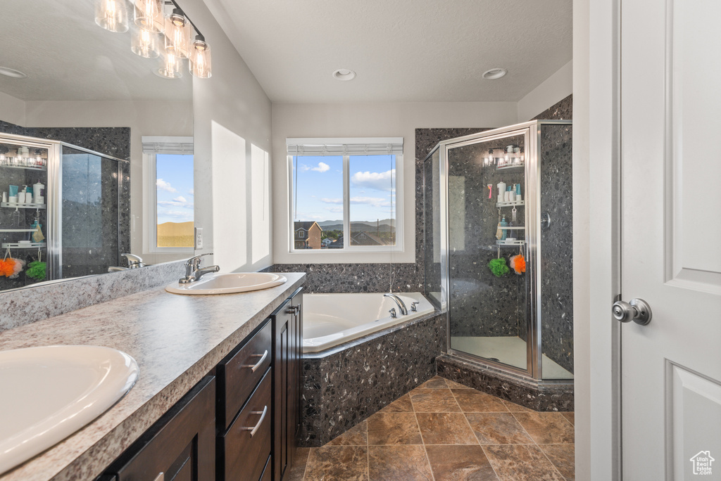 Full bathroom featuring a bath, a stall shower, double vanity, and recessed lighting