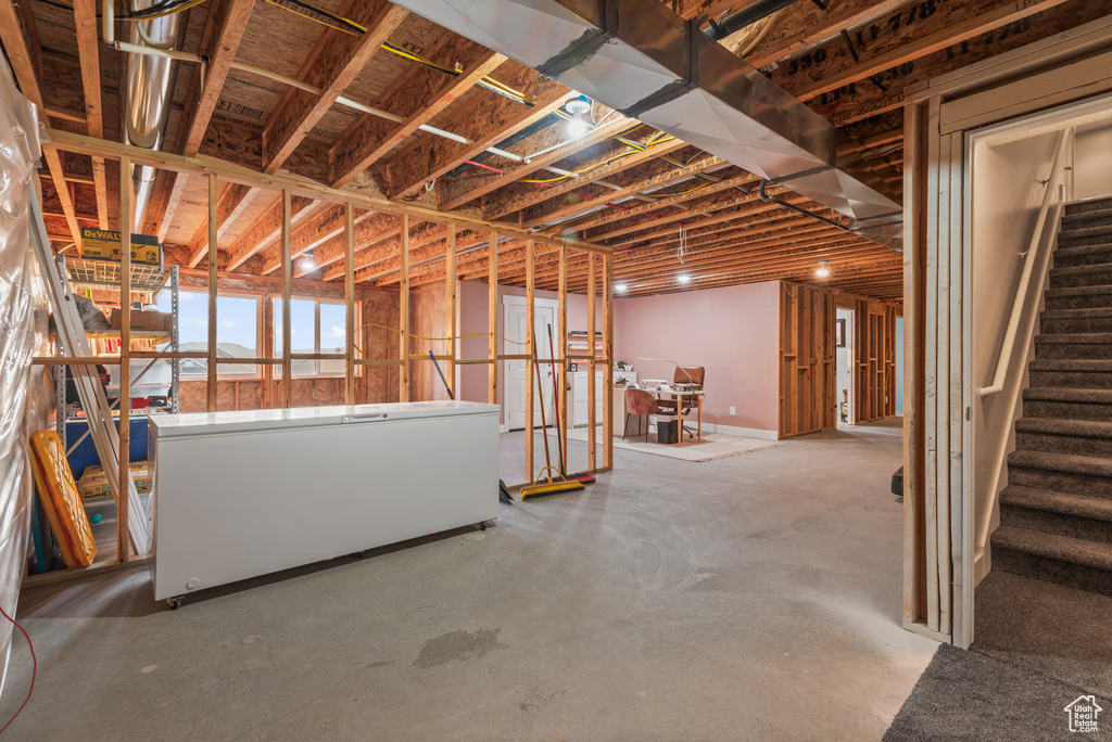 Basement featuring fridge and stairs