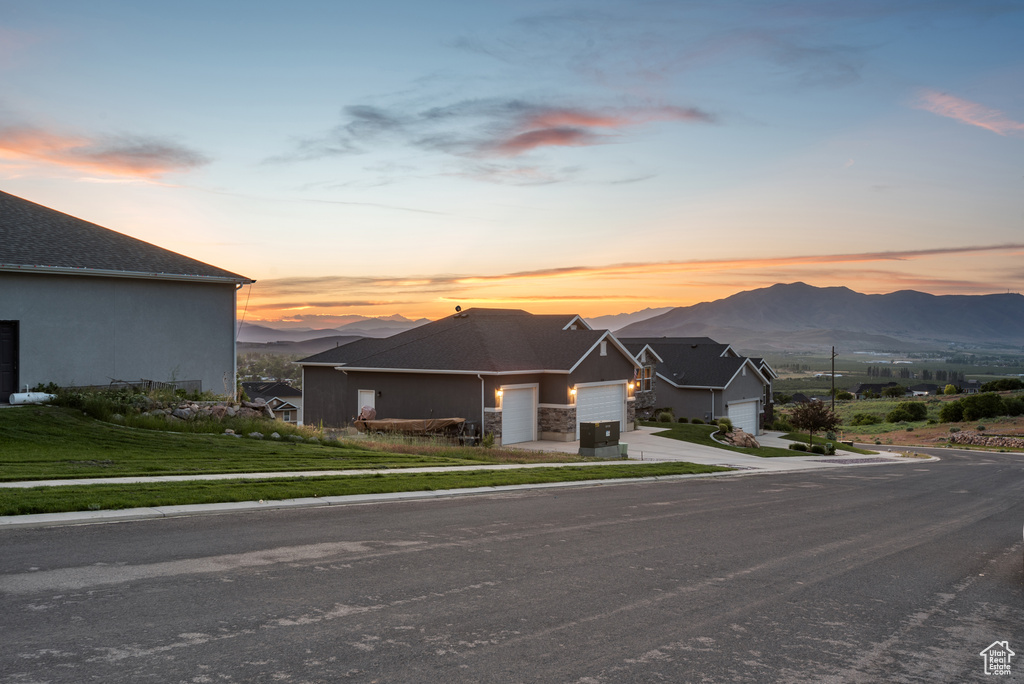 View of front of house with a garage, a mountain view, and driveway