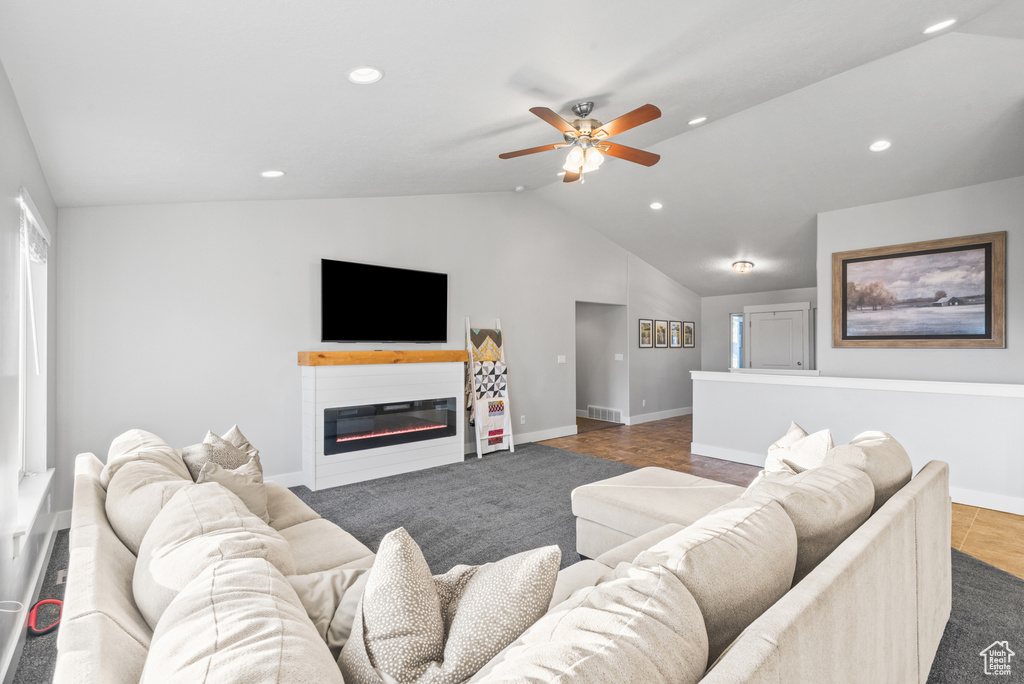 Living area featuring vaulted ceiling, baseboards, ceiling fan, recessed lighting, and a glass covered fireplace