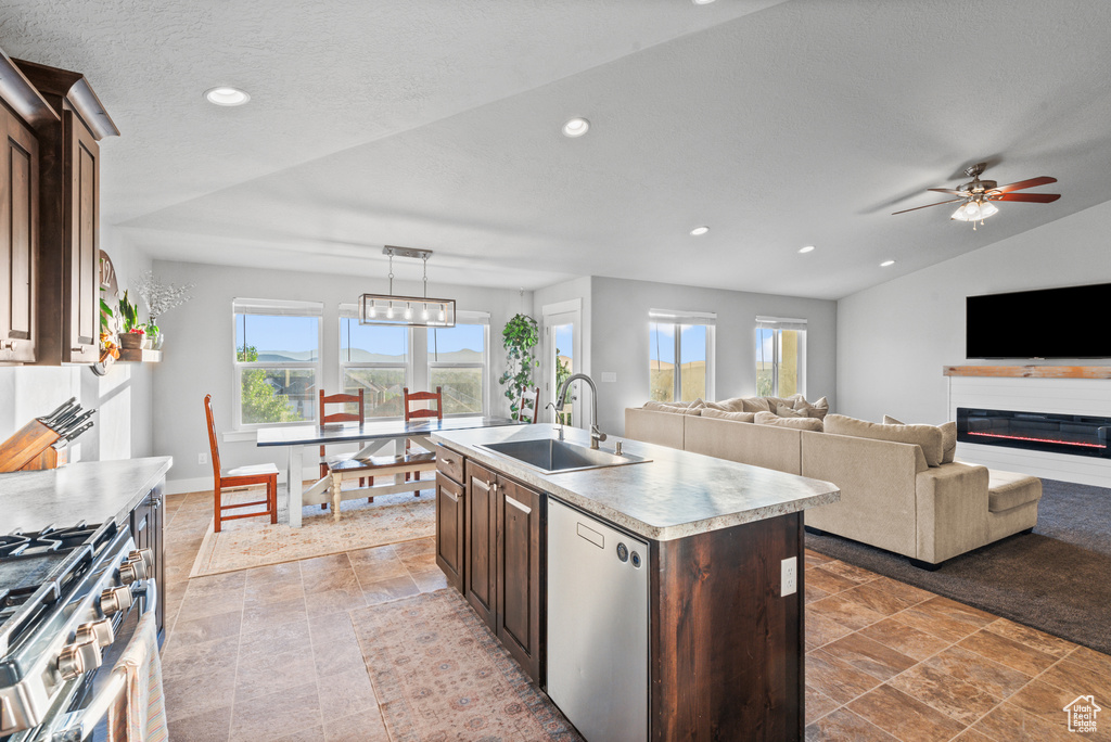 Kitchen with a sink, stainless steel appliances, recessed lighting, dark brown cabinets, and a center island with sink