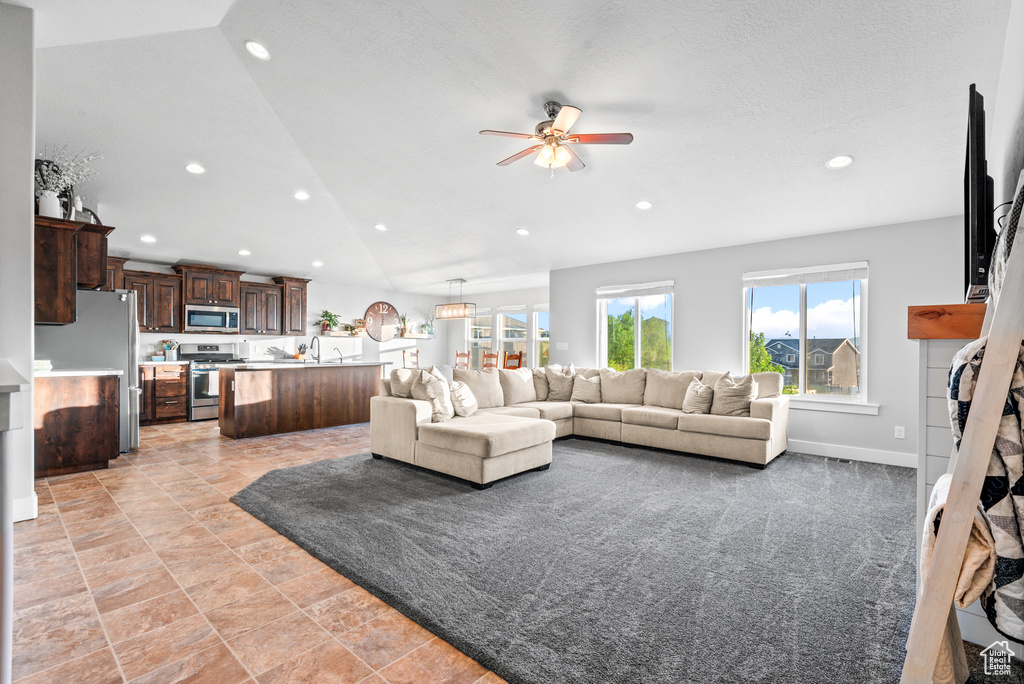 Living room with a ceiling fan, vaulted ceiling, and recessed lighting