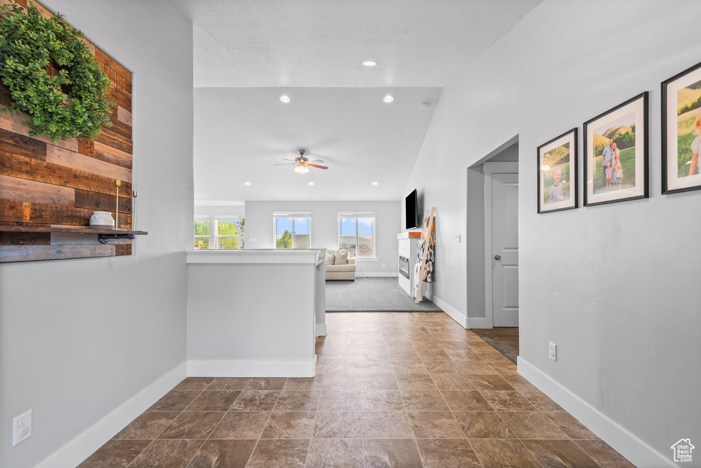 Corridor featuring baseboards, recessed lighting, and dark stone finish floors