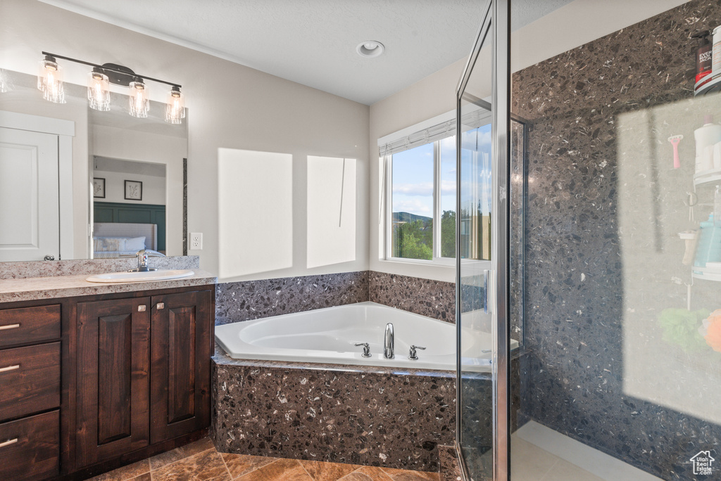 Full bath featuring a shower stall, a garden tub, and vanity