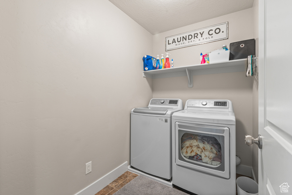 Washroom featuring washer and clothes dryer and baseboards